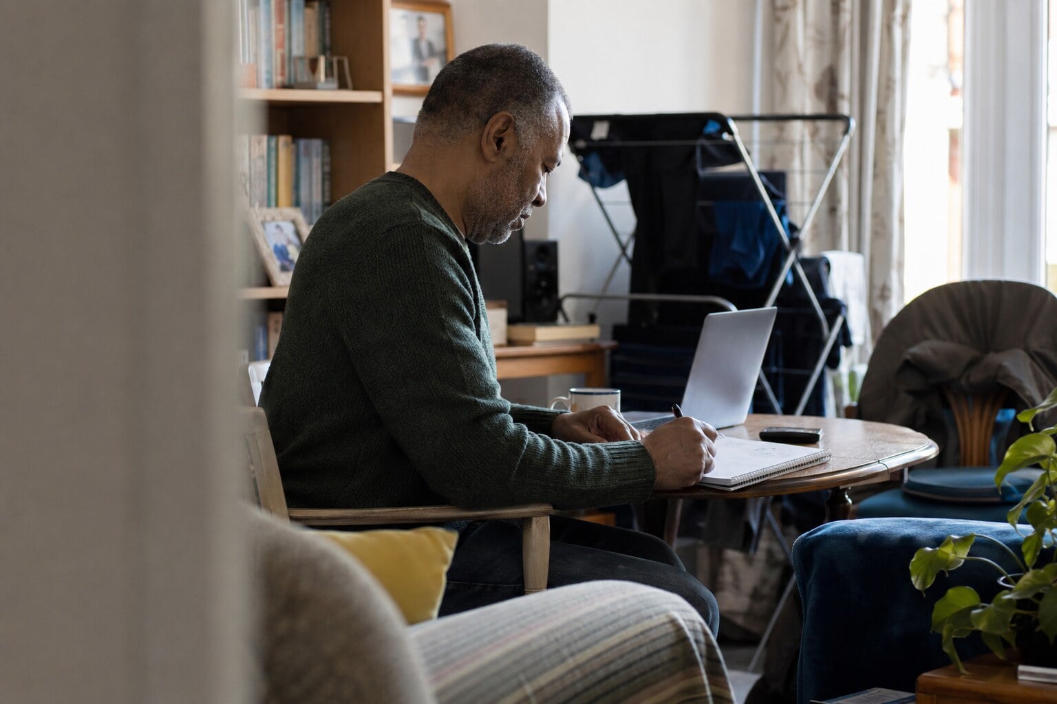 A foster carer and a teenage girl sitting at a kitchen table with a diary and paperwork, talking through plans