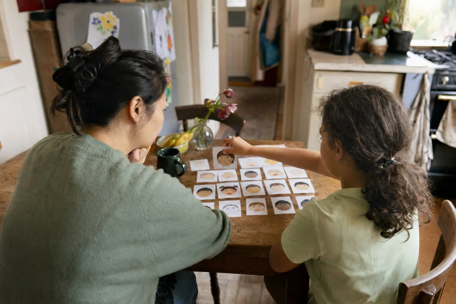 An adult and a child looking at illustrated cards together