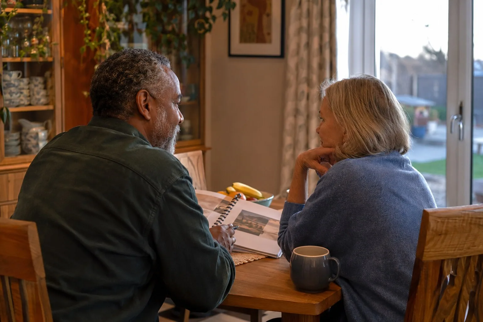 Two adults talking together at their kitchen table