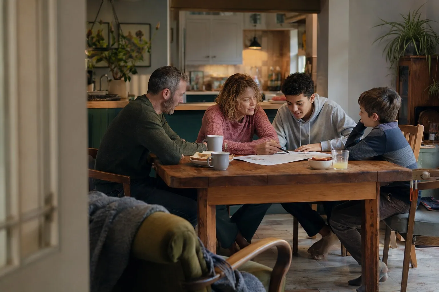 Adults and children talking and drawing together around a table