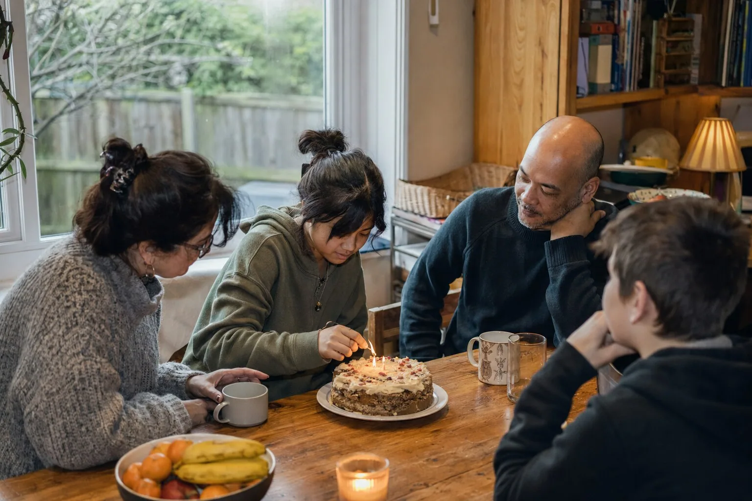 Adults and children gathered around a birthday cake