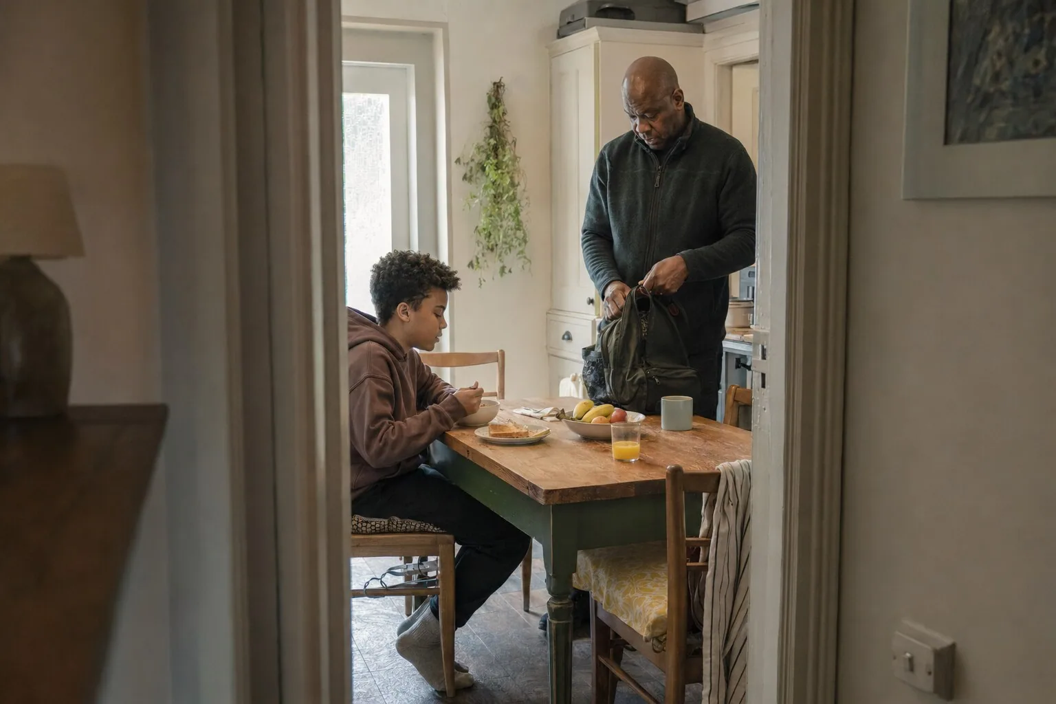 A man and a child getting breakfast ready at a kitchen table