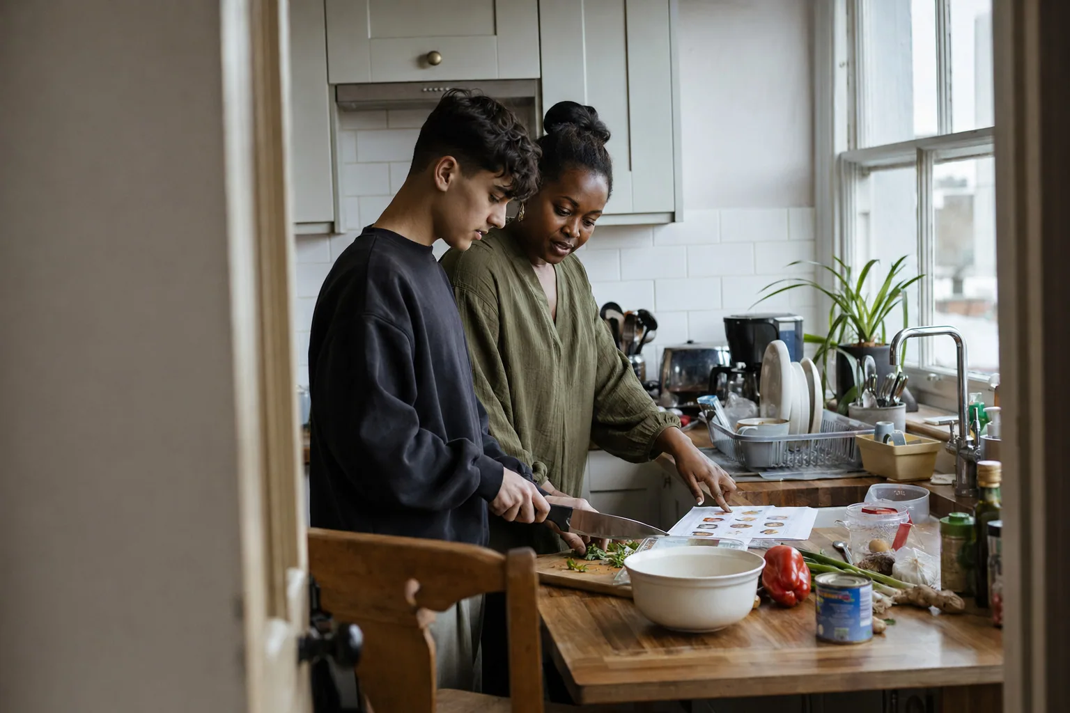 An adult and a teenager preparing vegetables together