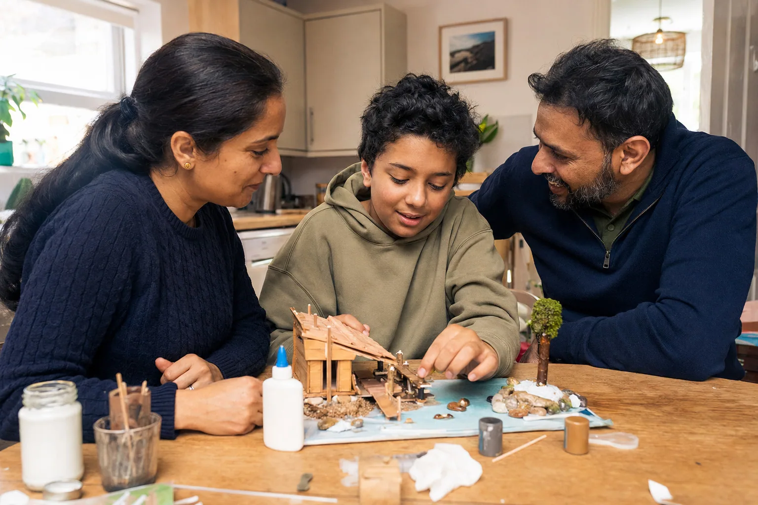 A child showing two adults a model they have made