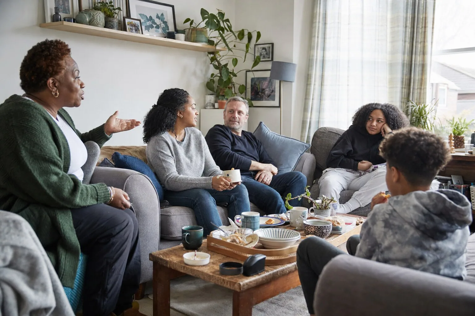 Adults and young people talking together in a living room